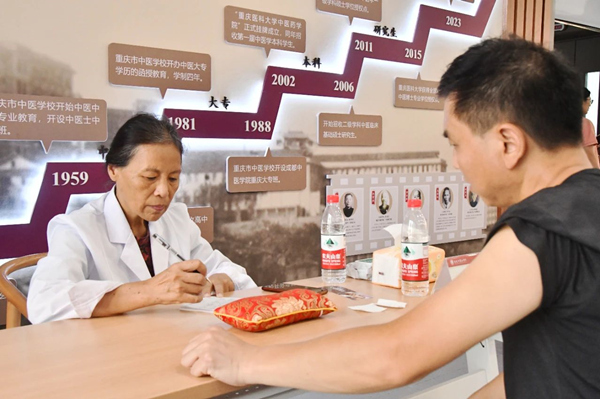重庆市名中医、bat365中文官方网站教授洪蕾为学生家长看诊。bat365中文官方网站供图